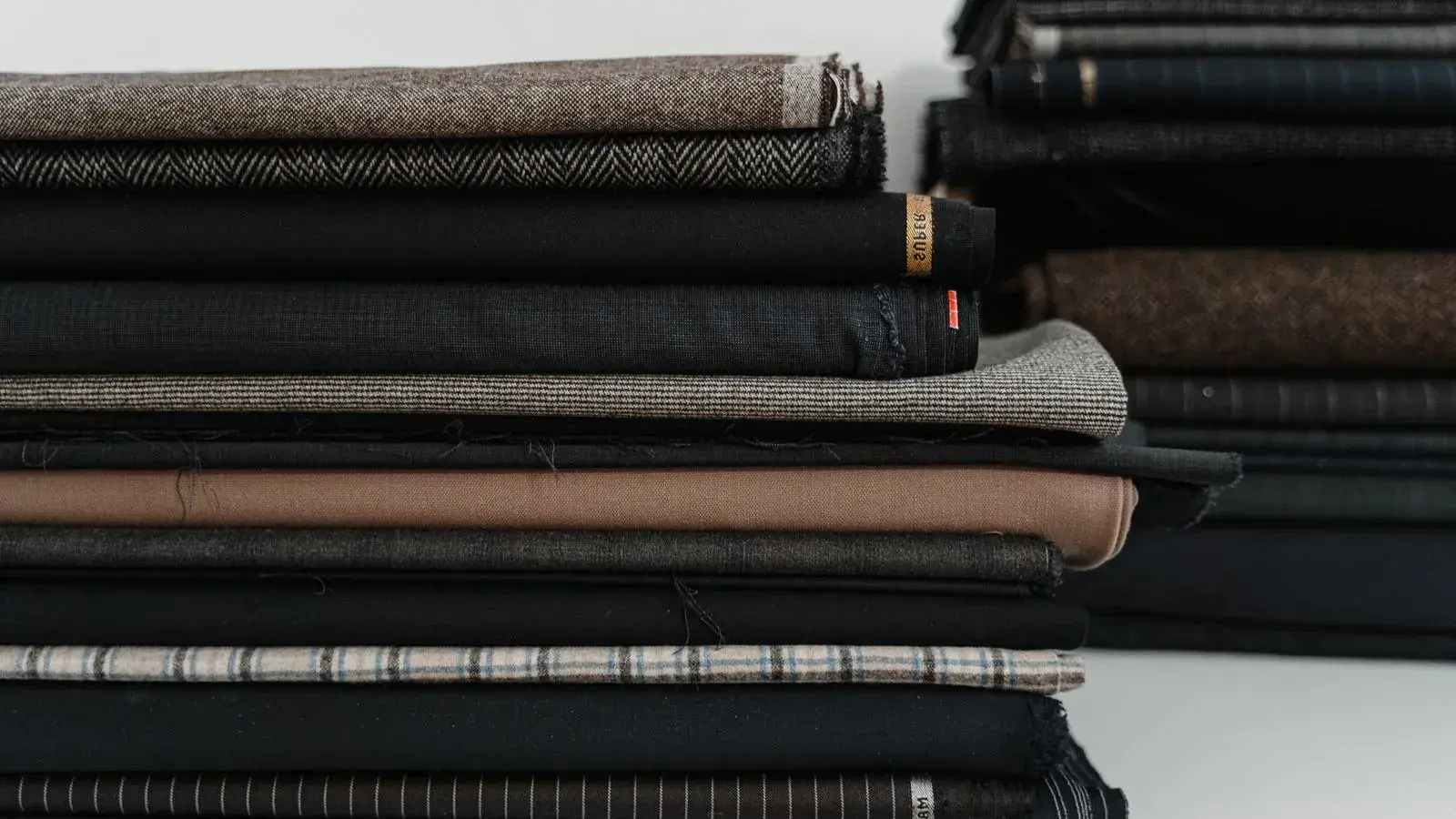 Stacks of folded fabrics in different colors and constructions