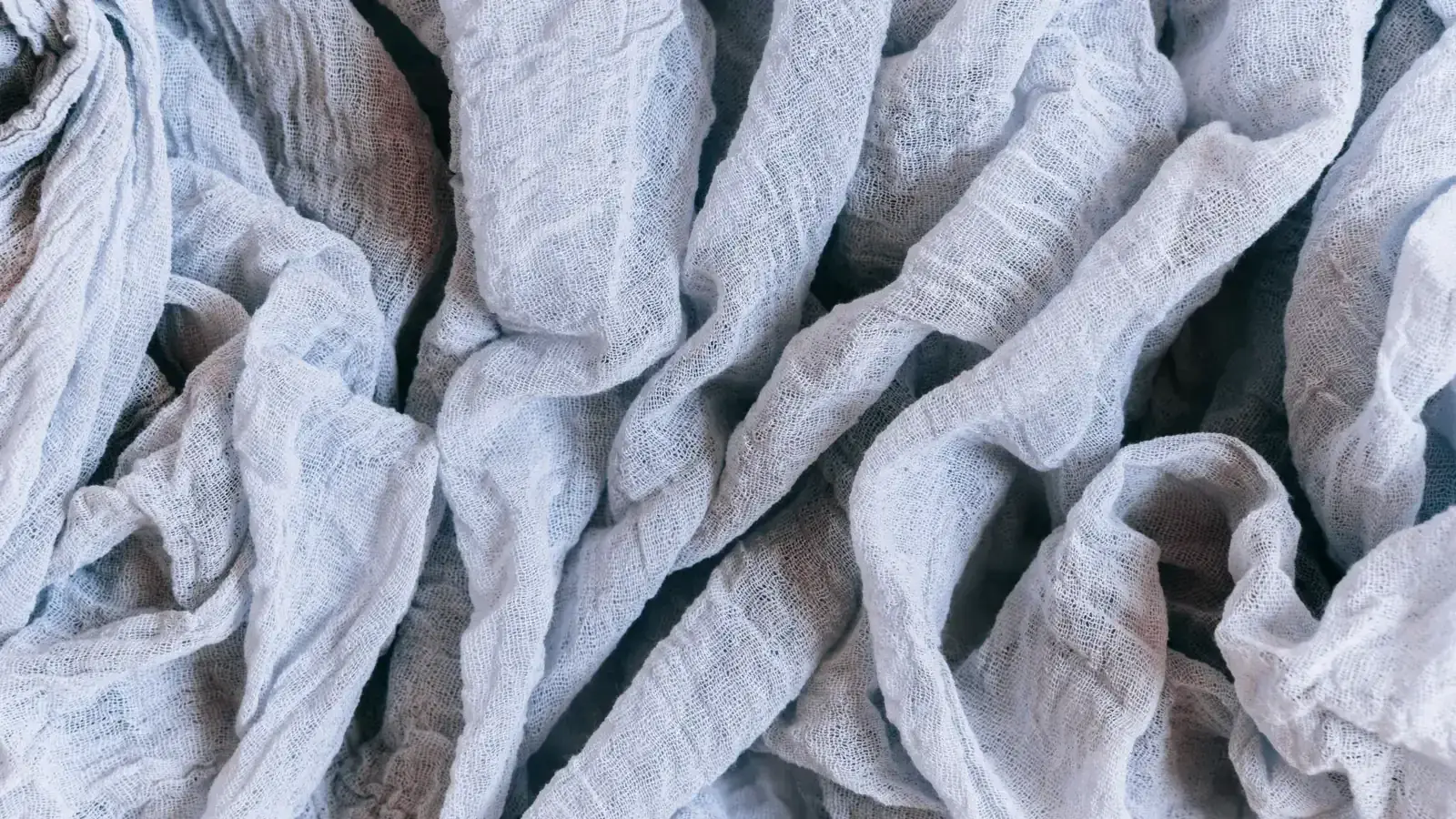 Loose folds of pale washed fabric showing drape and surface break