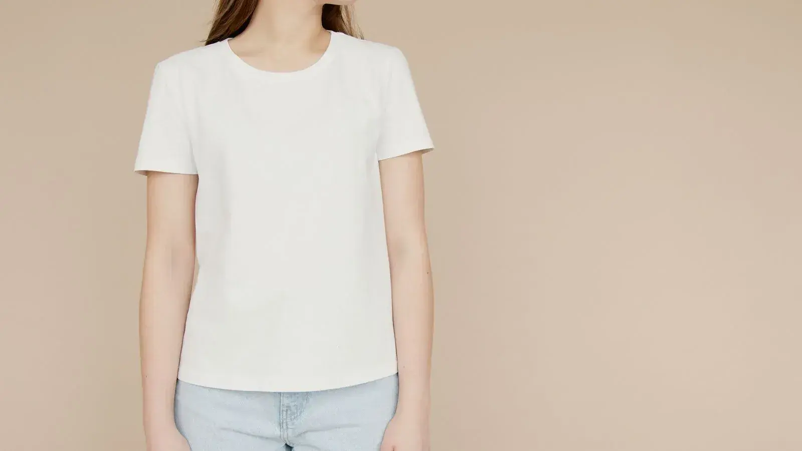 Model wearing a plain white crew-neck T-shirt against a beige background