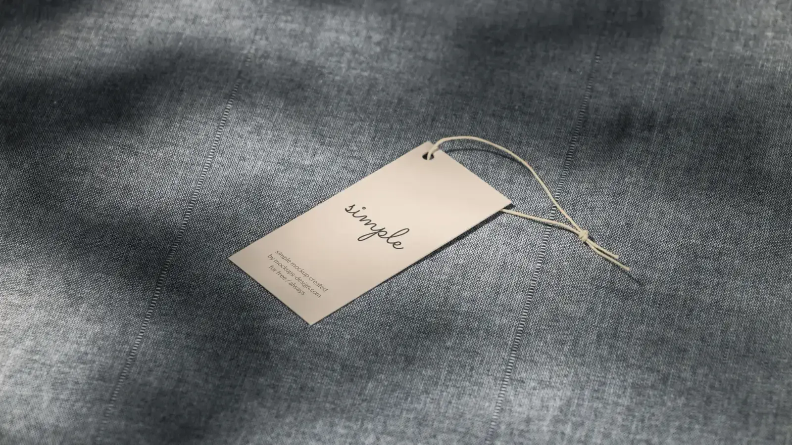A single unbranded hang tag on a chambray-textured fabric surface