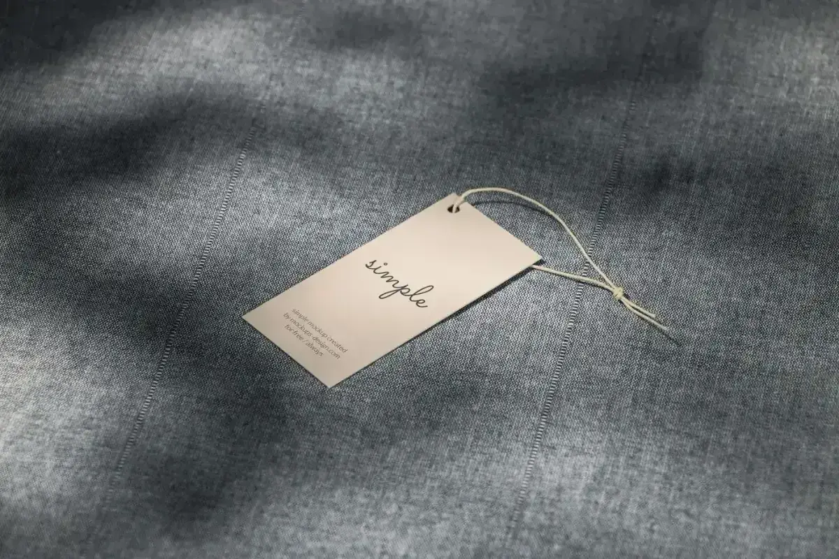 A paper hang tag resting on gray woven fabric
