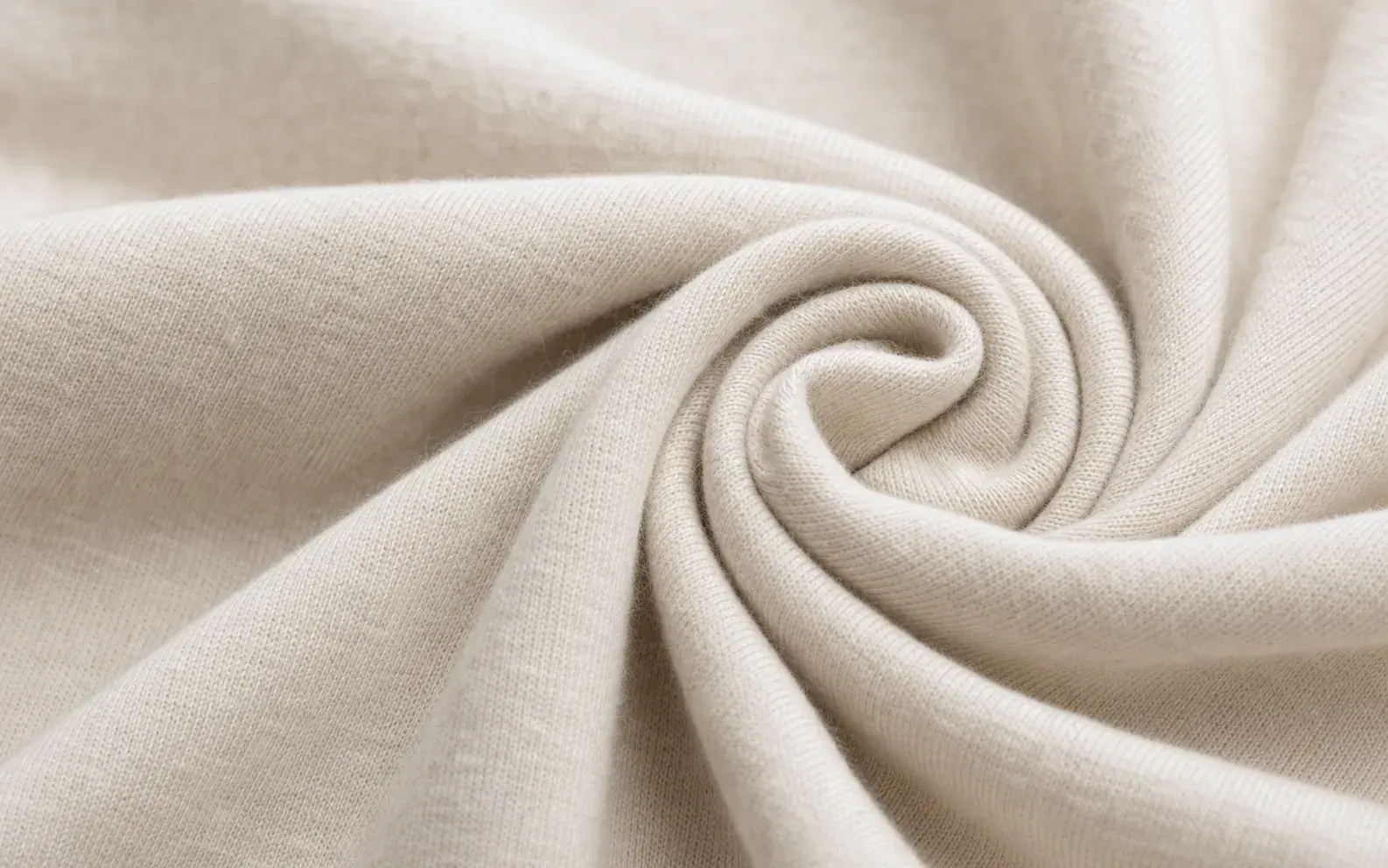 Close-up of soft natural fabric twisted to show fiber texture.