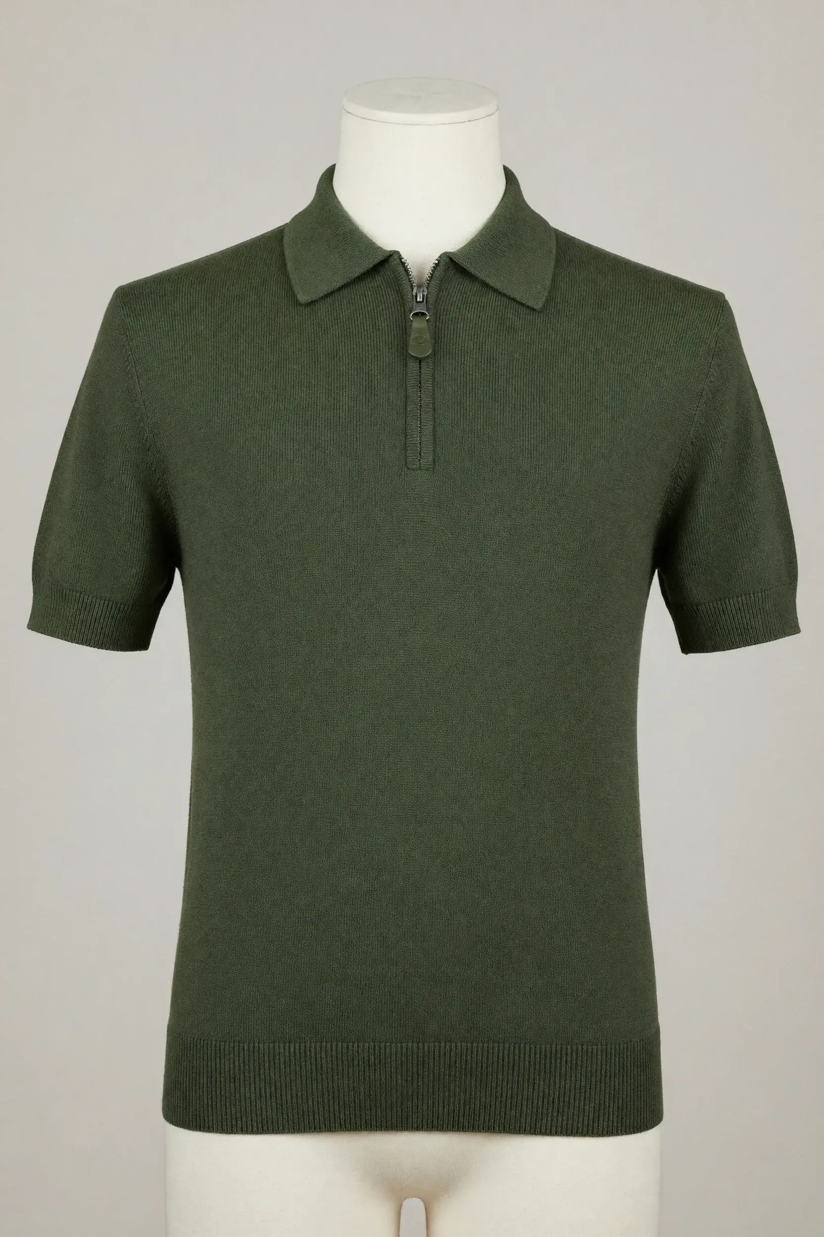 Moss-green quarter-zip short-sleeve knit polo with collar and ribbed edges displayed on a mannequin for private-label development