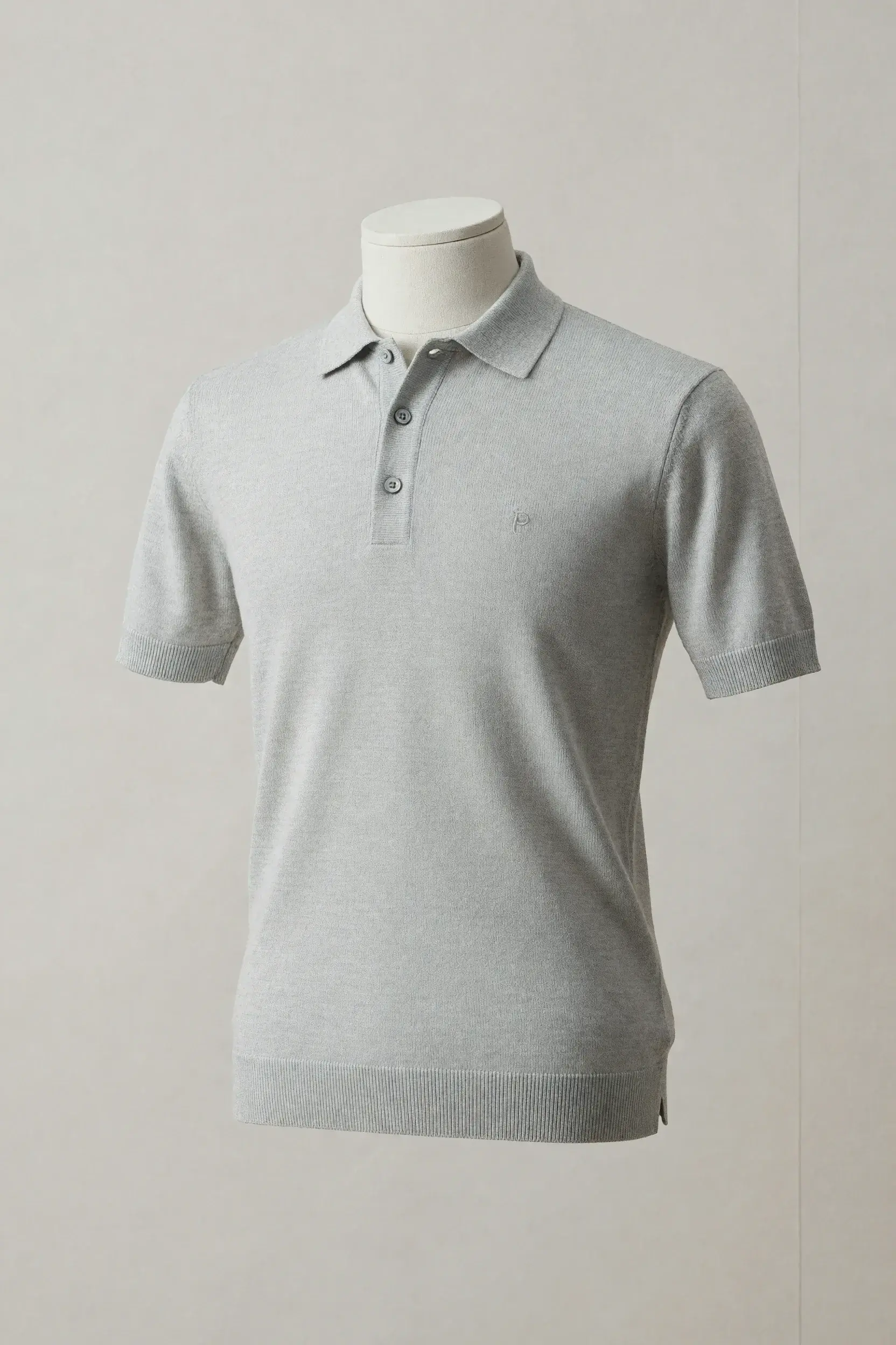 Pearl-grey short-sleeve knit polo with three-button placket, ribbed cuffs and hem and side vents on a display mannequin for private-label development