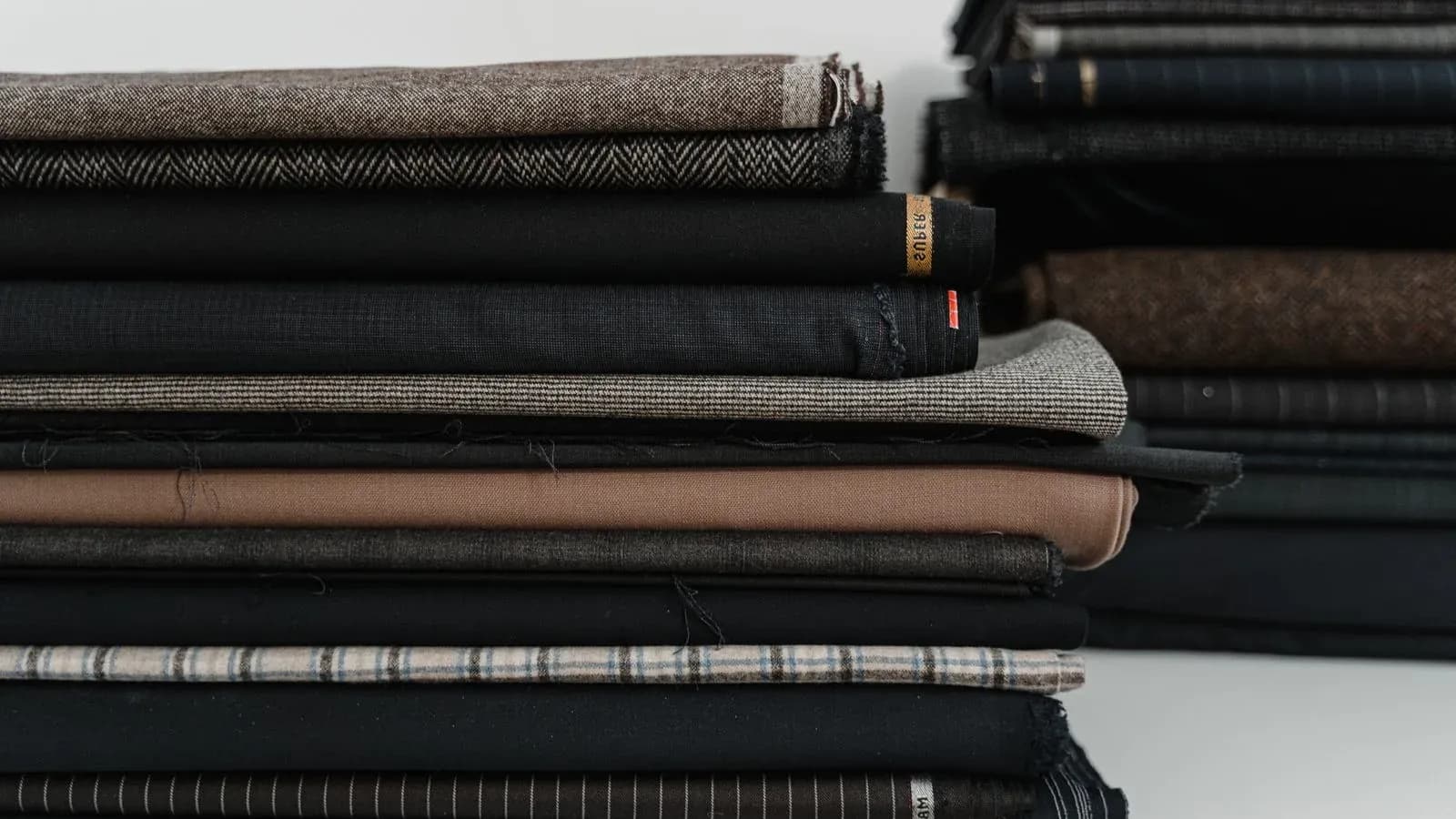 Stacks of folded fabrics in different colors and constructions