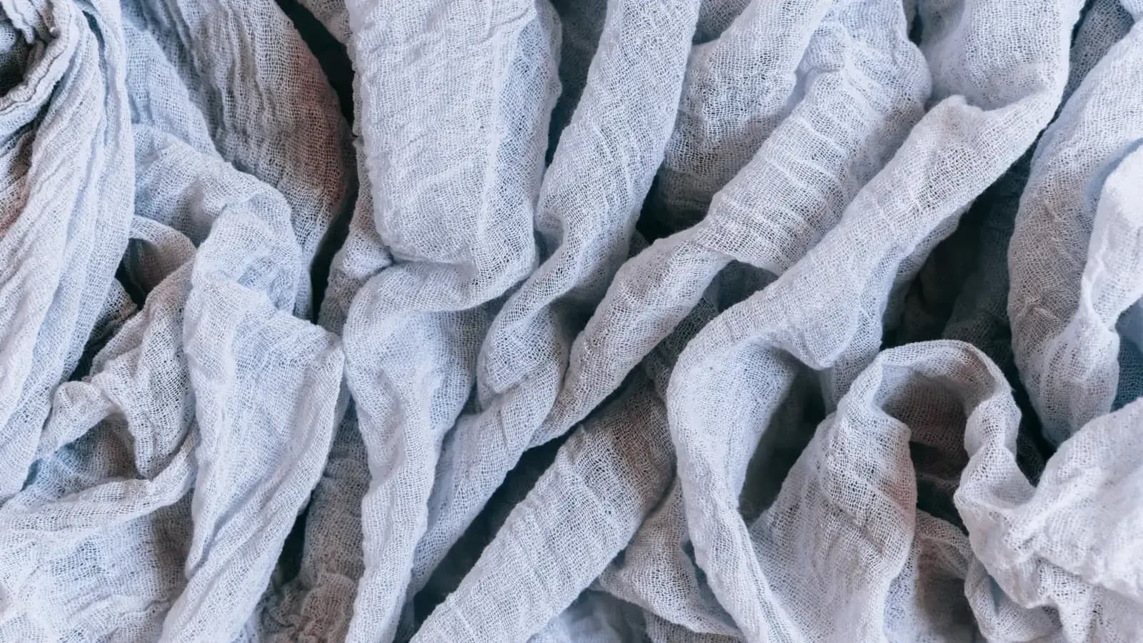 Loose folds of pale washed fabric showing drape and surface break
