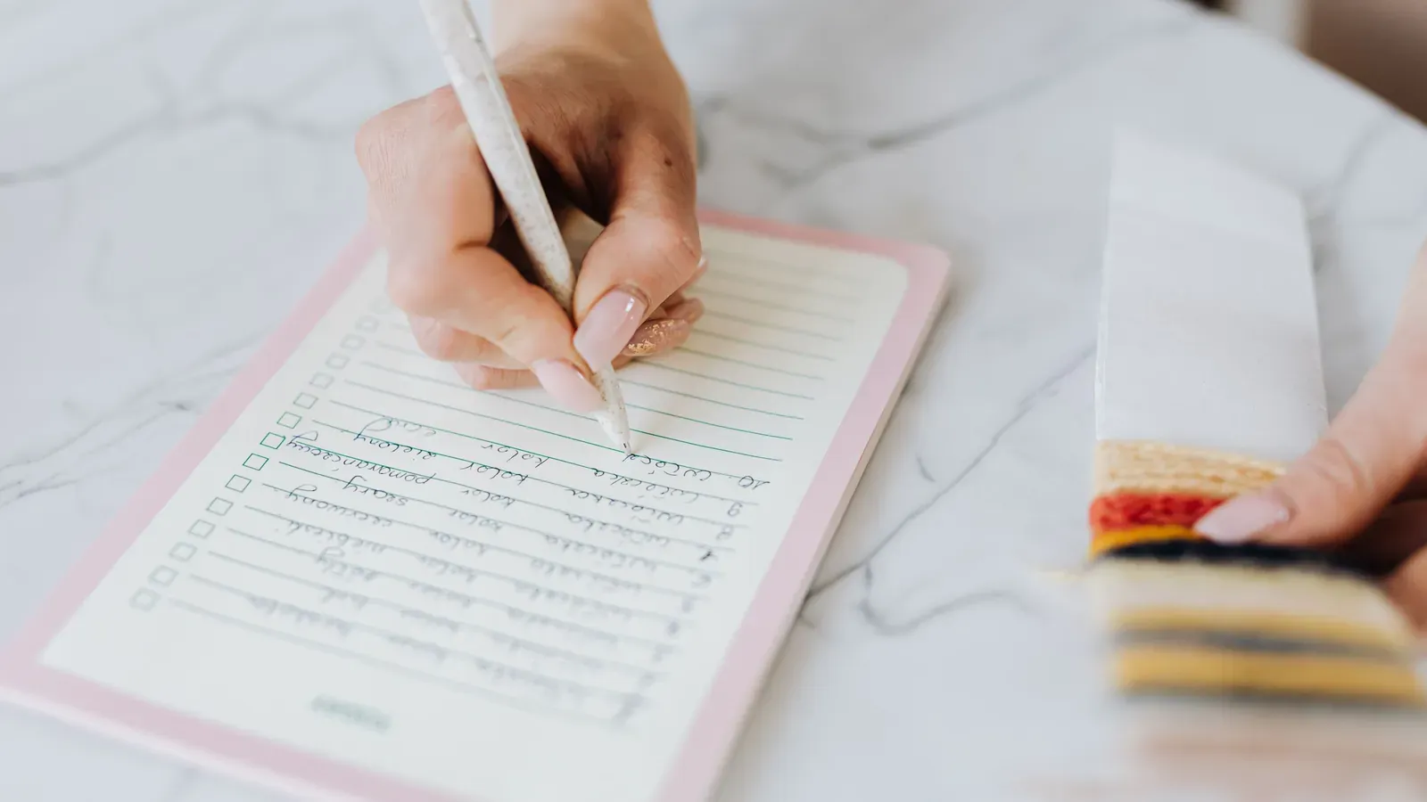 Designer completing a checklist beside fabric swatches for a garment sample request