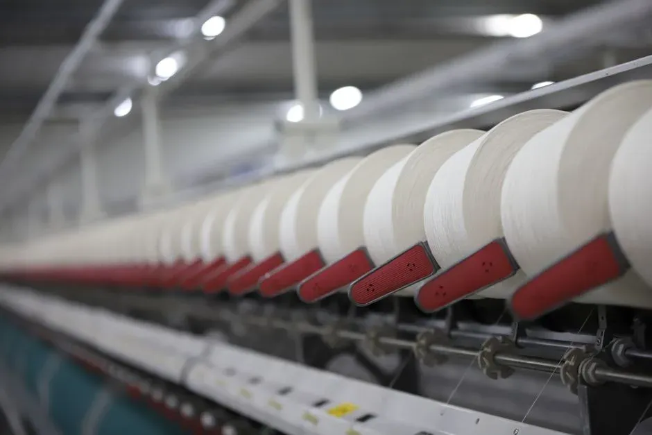White yarn bobbins on a spinning production line