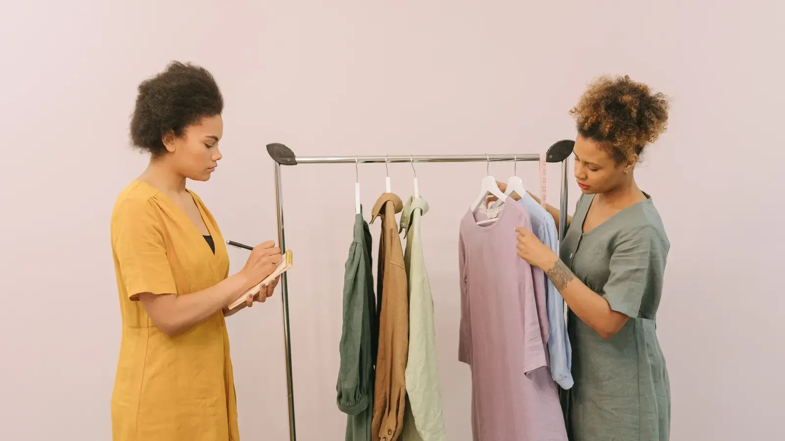 Two apparel buyers reviewing garments on a clothing rack