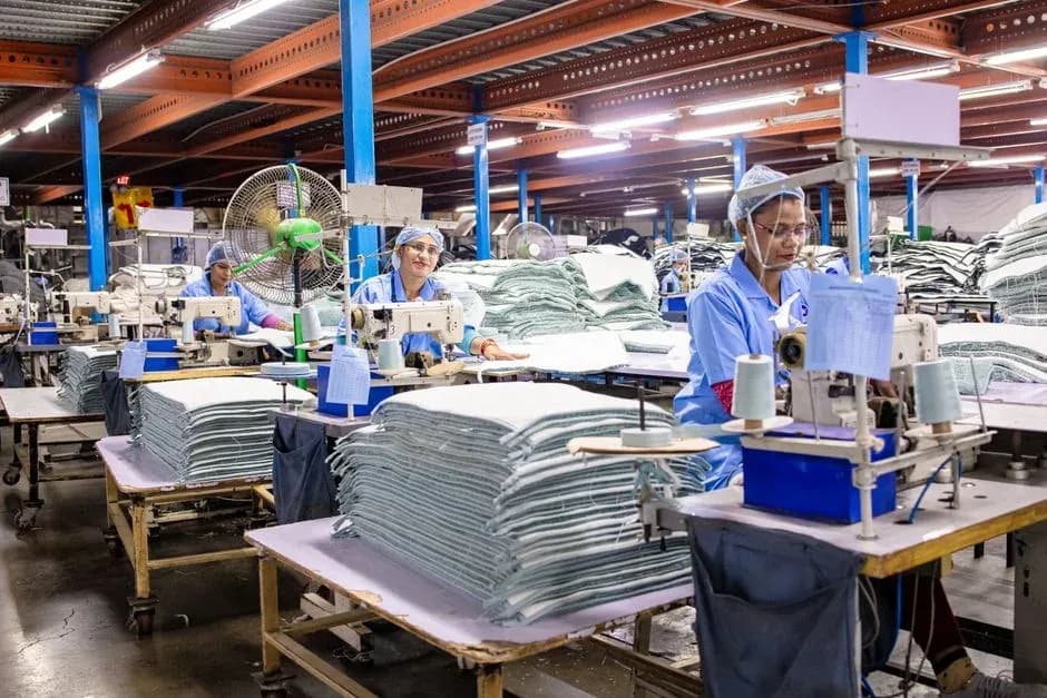 Workers at sewing machines on a garment production floor