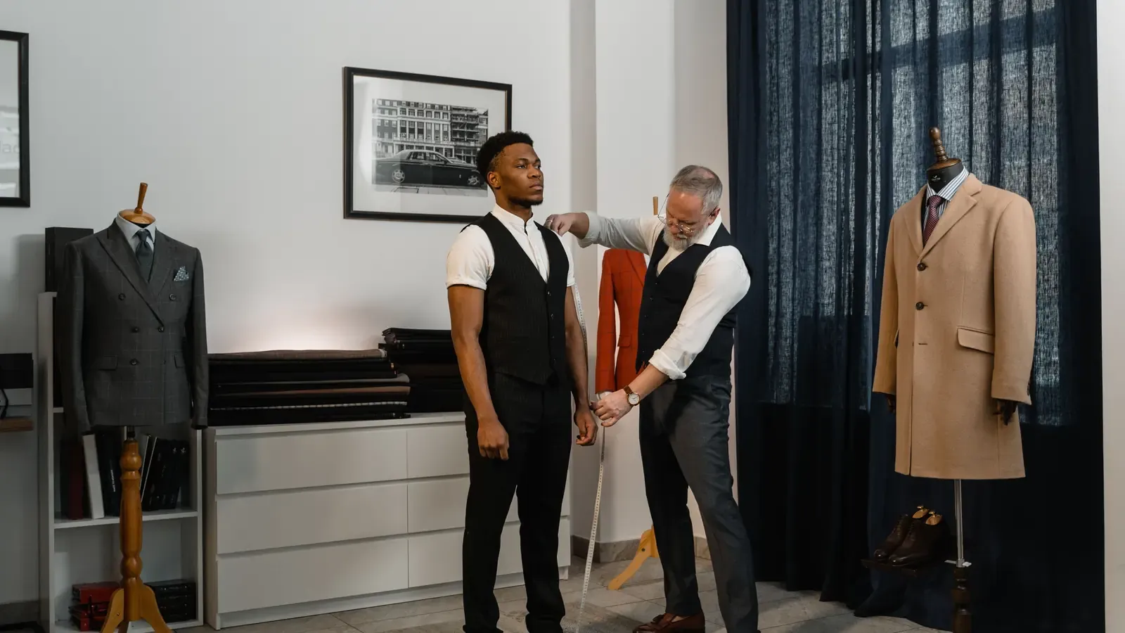 Tailor checking sleeve length and balance during a menswear fitting
