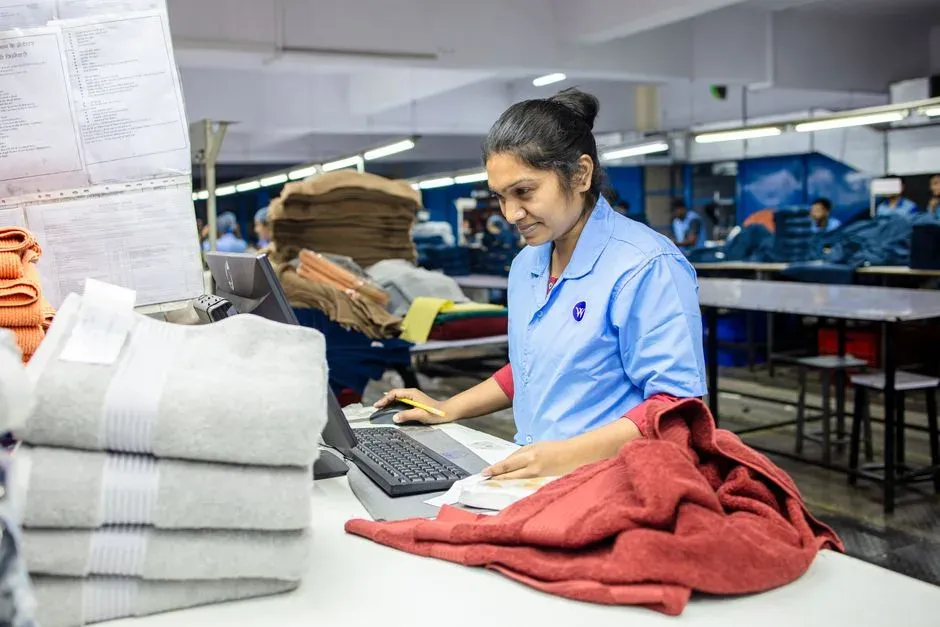 A textile worker checking fabric at an inspection workstation