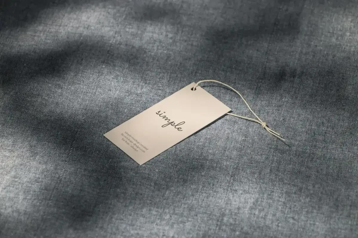 A paper hang tag resting on gray woven fabric