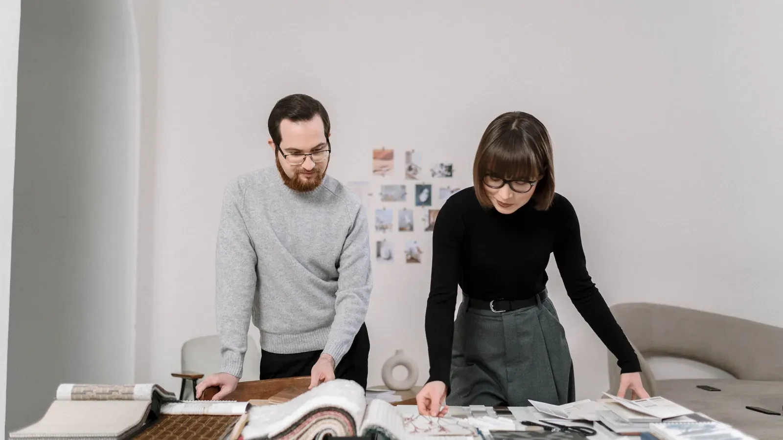 Two product developers reviewing fabric swatch books at a worktable