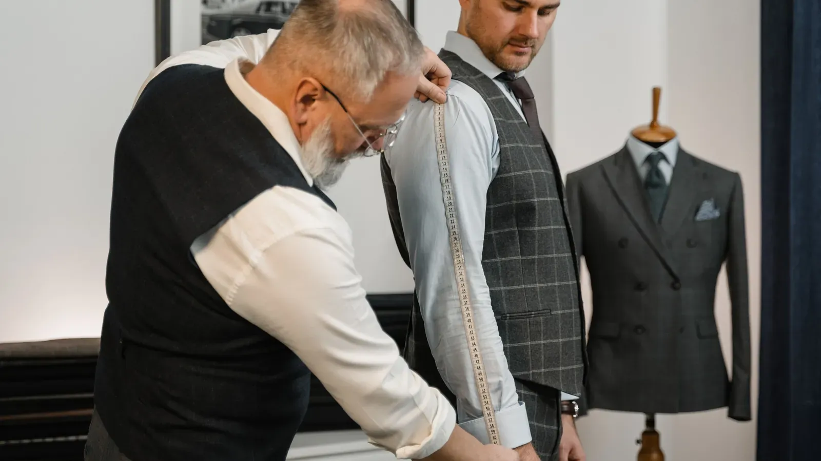 Tailor measuring a shirt sleeve to define sample fit and size