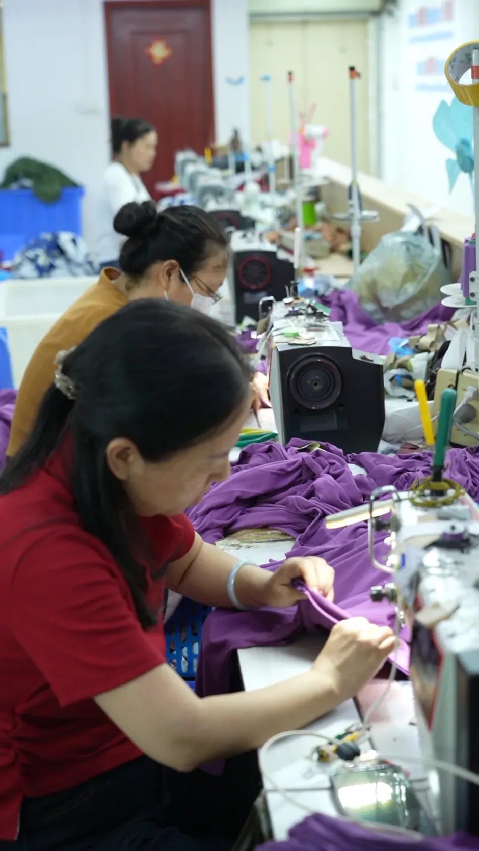 A sewing operator working with purple fabric on the Cynida production floor