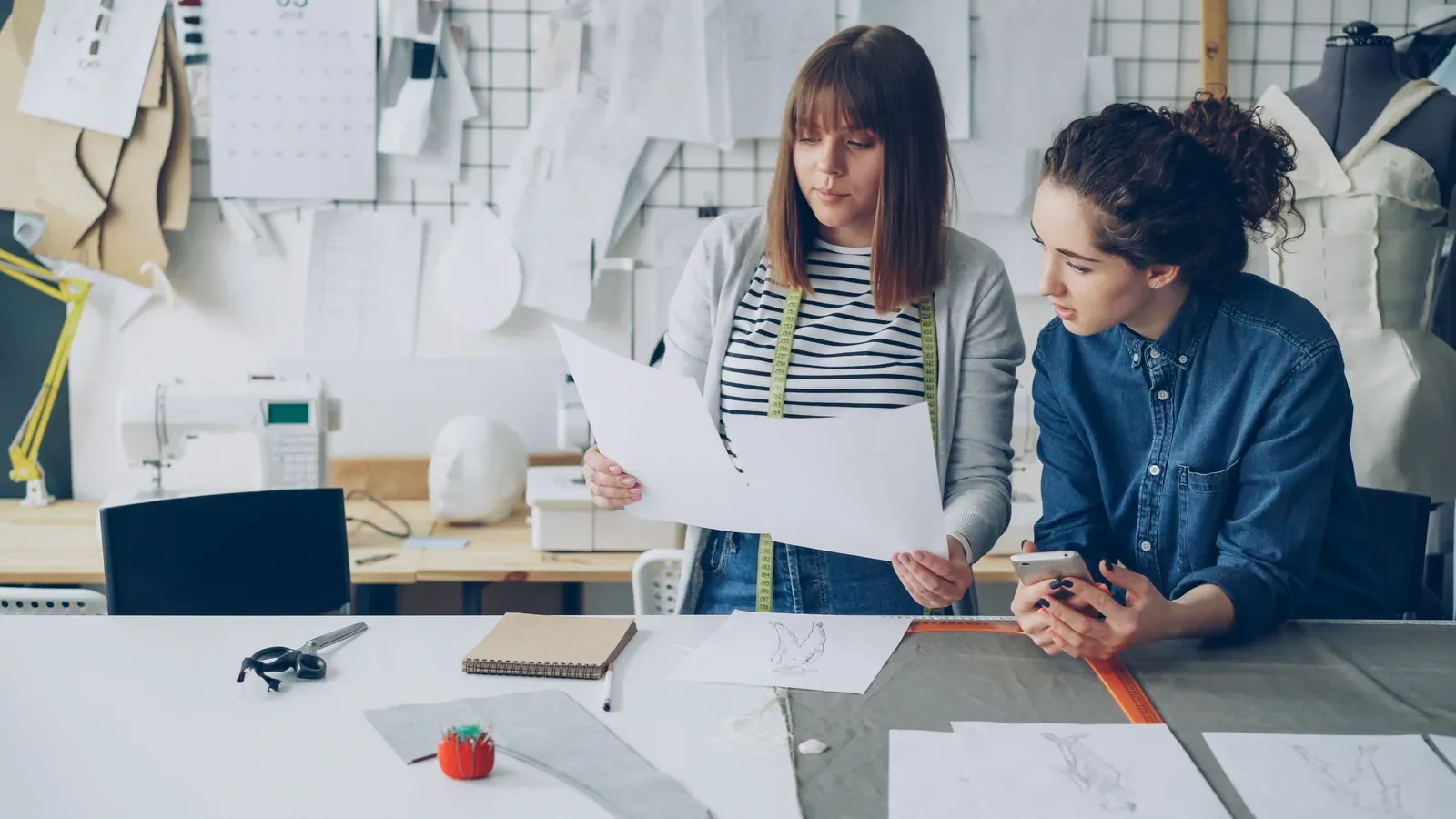 Fashion designers reviewing garment specifications and sample questions