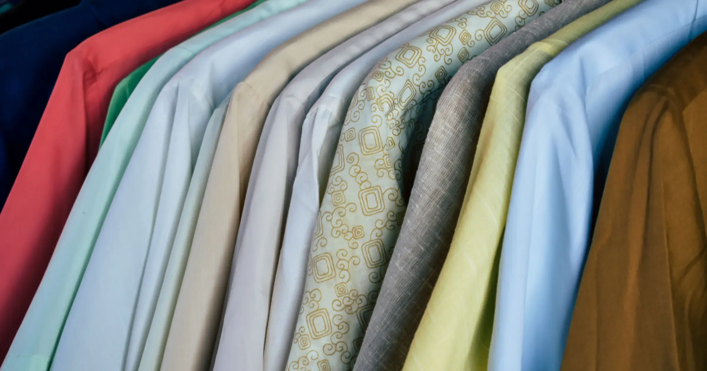Assorted collared polo shirts hanging together on a retail rack
