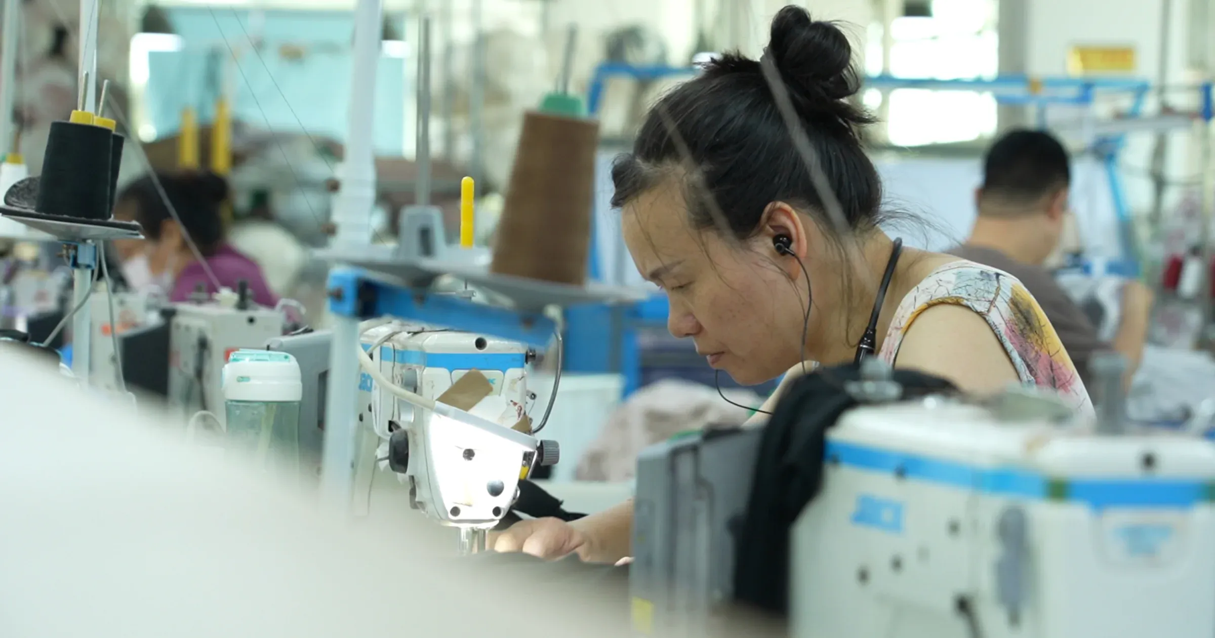 A sewing operator working at an industrial machine on the Cynida production floor