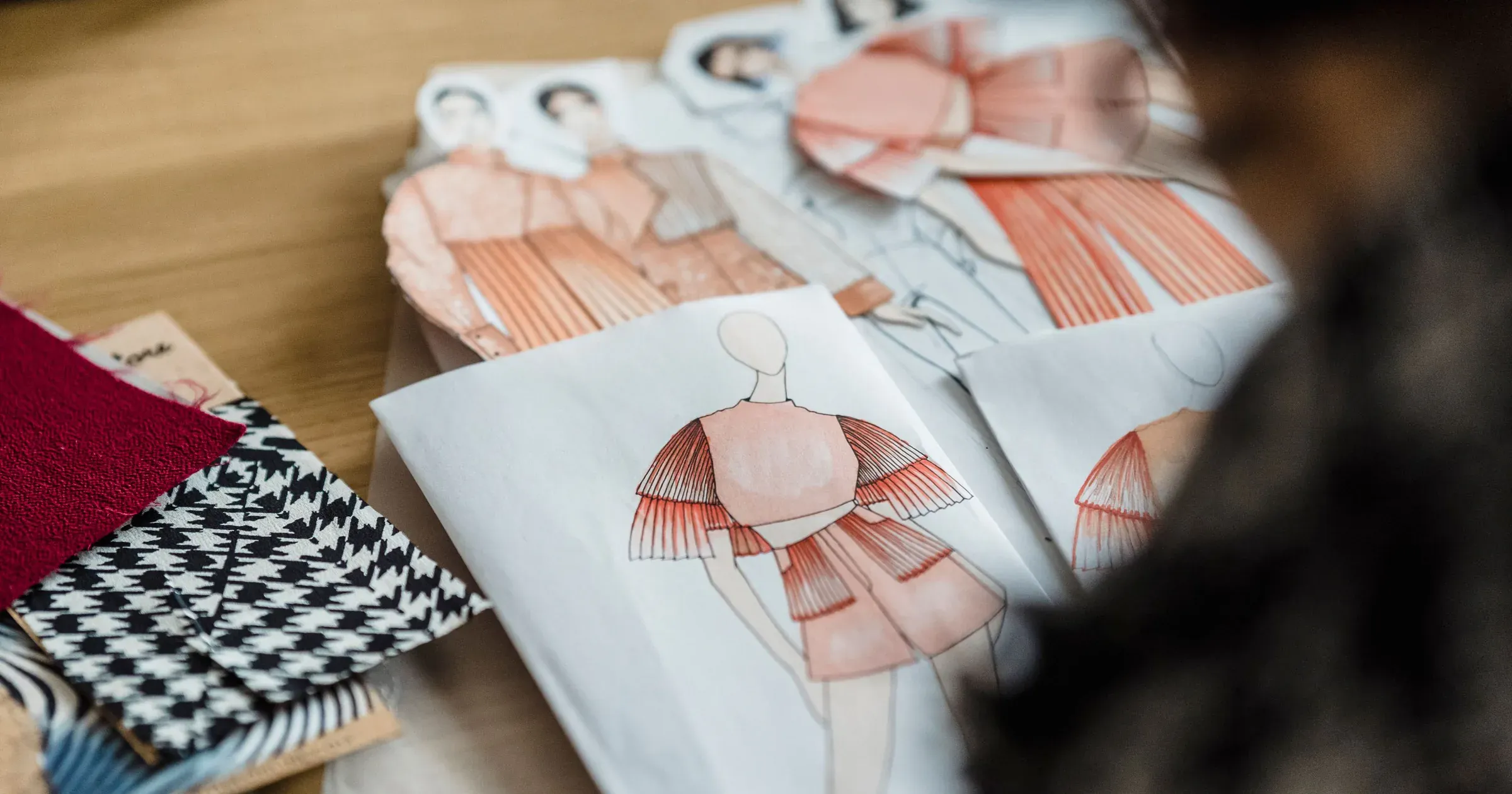 Fashion sketches and fabric swatches arranged on a designer's worktable