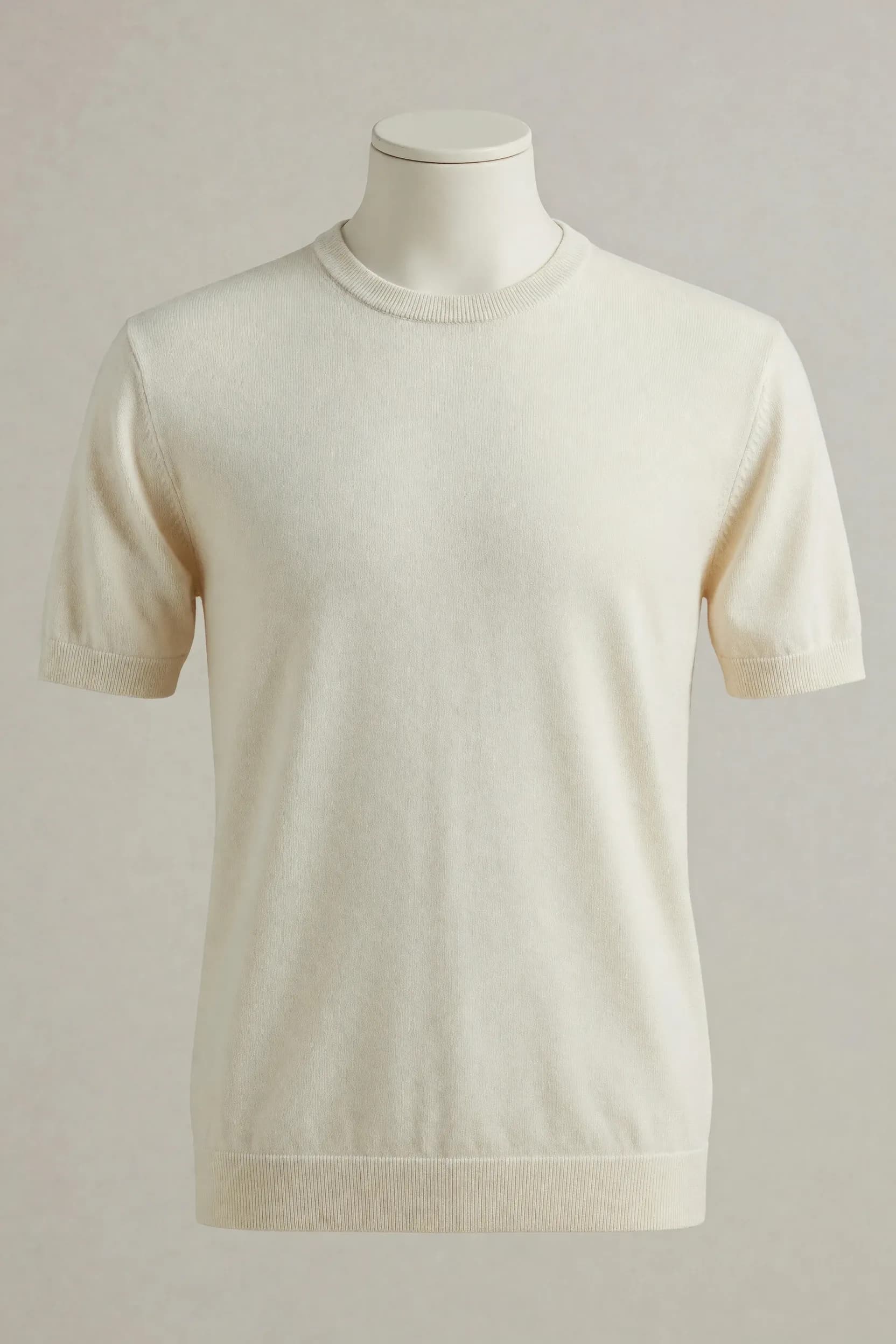 Ivory short-sleeve crew-neck knit T-shirt with a broad ribbed hem and finished neck and cuffs shown on a faceless mannequin for private-label sourcing
