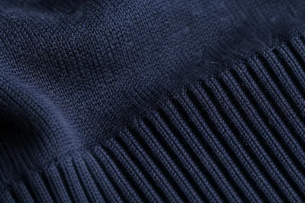 Fine-gauge navy merino knit showing a rib transition and even stitch tension