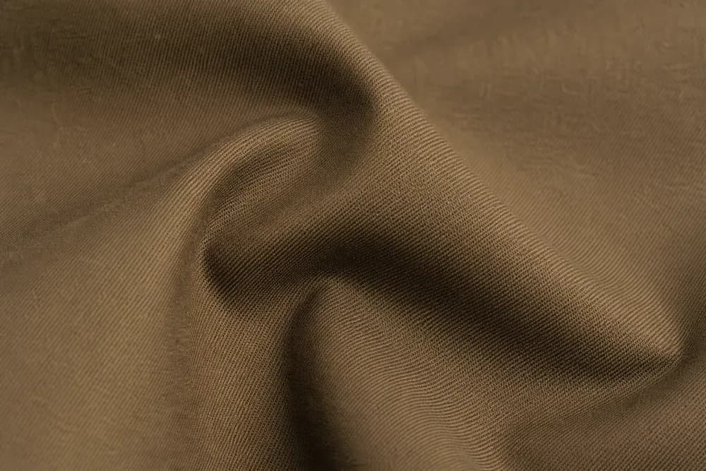 Tobacco stretch-cotton trouser fabric folded to show density and recovery