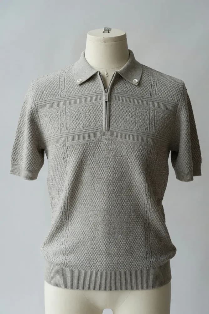 Light-stone short-sleeve knit polo with half-zip collar, geometric chest panel and textured body shown on a faceless mannequin for private-label sourcing
