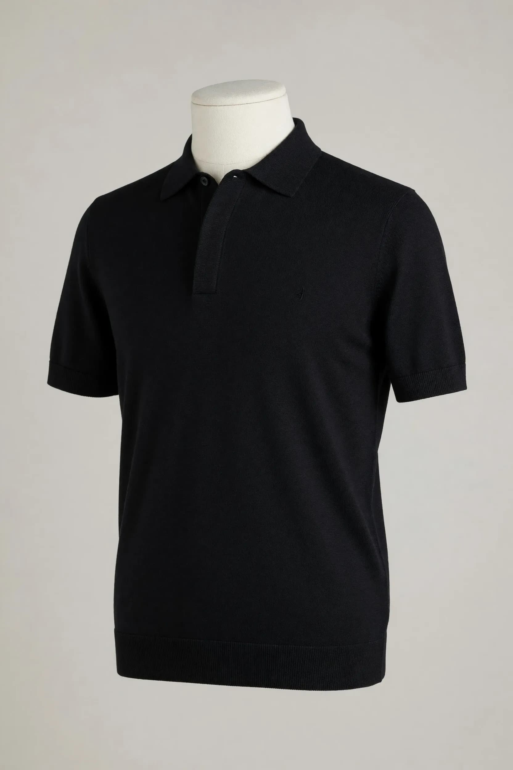 Black hidden-placket short-sleeve knit polo with collar and ribbed hem shown on a mannequin for private-label development