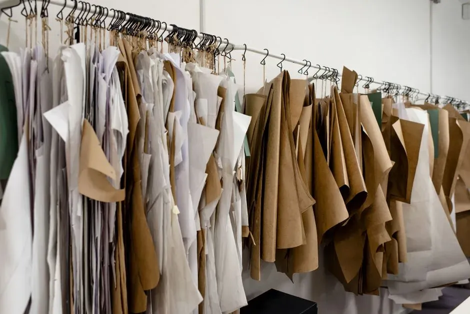 Paper sewing patterns hanging on rails in a tailoring atelier