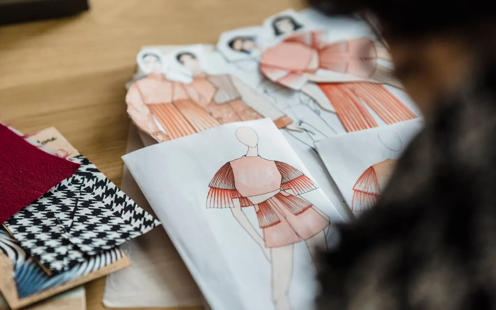 Fashion sketches and fabric swatches arranged on a designer's desk