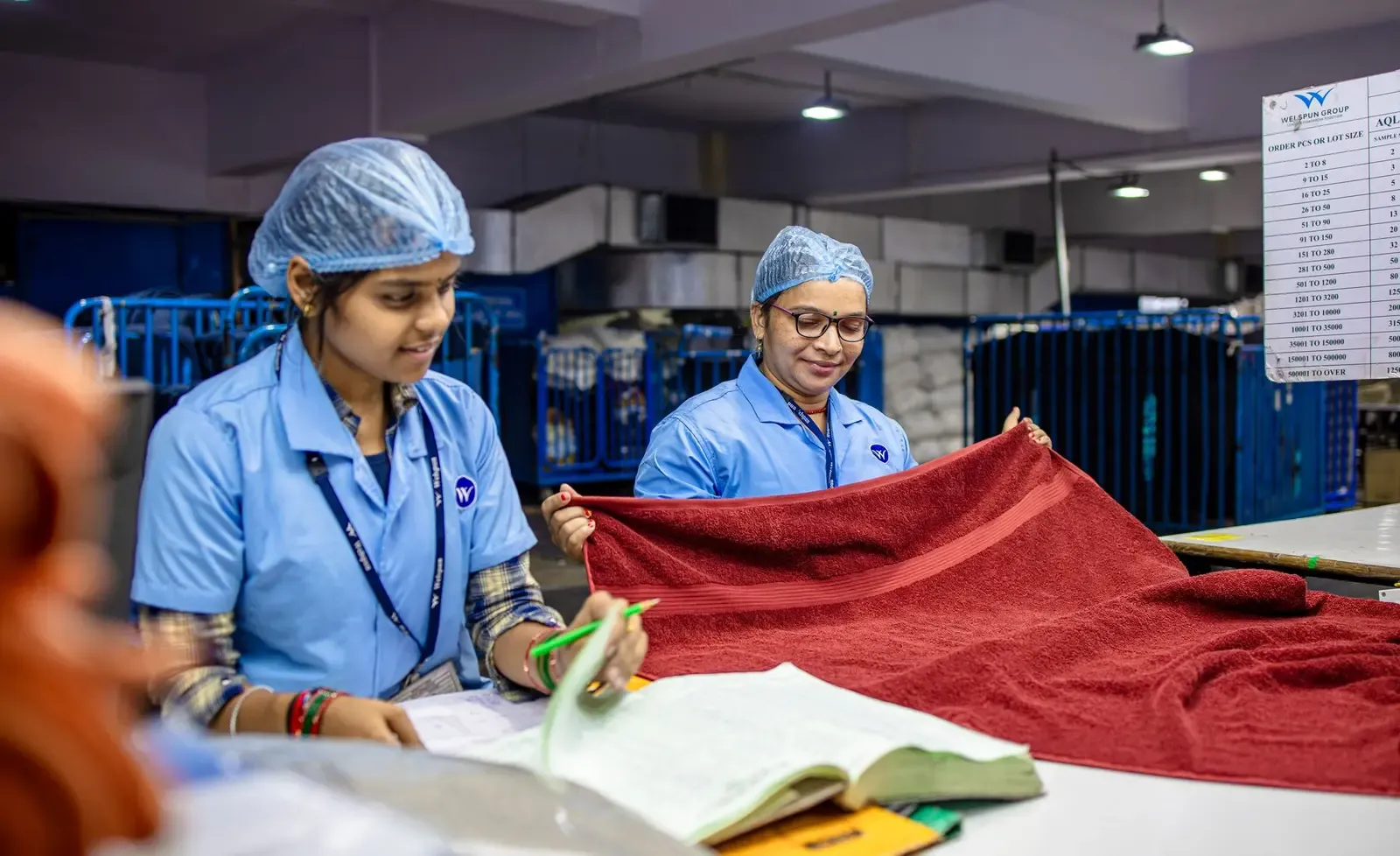 Textile workers inspecting fabric before it proceeds through production