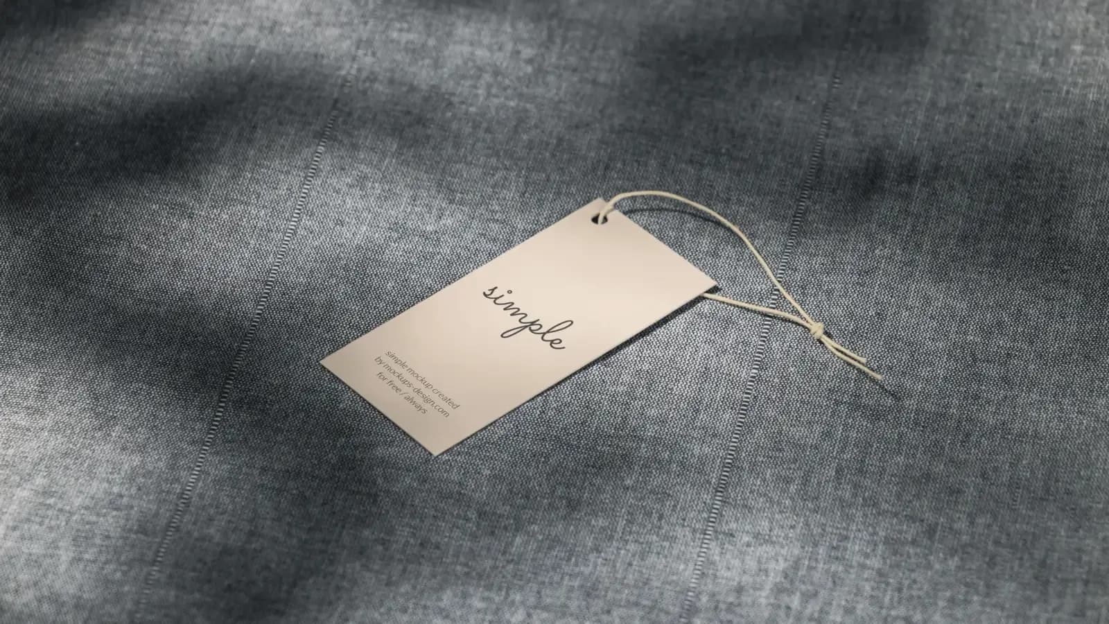 A single unbranded hang tag on a chambray-textured fabric surface