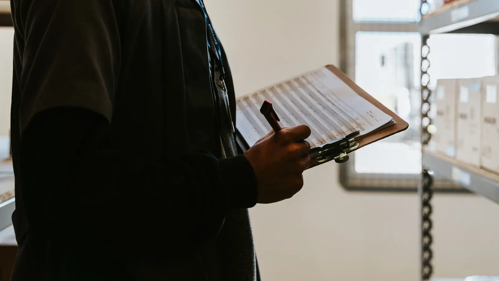 Quality controller holding a clipboard with a checklist in a warehouse
