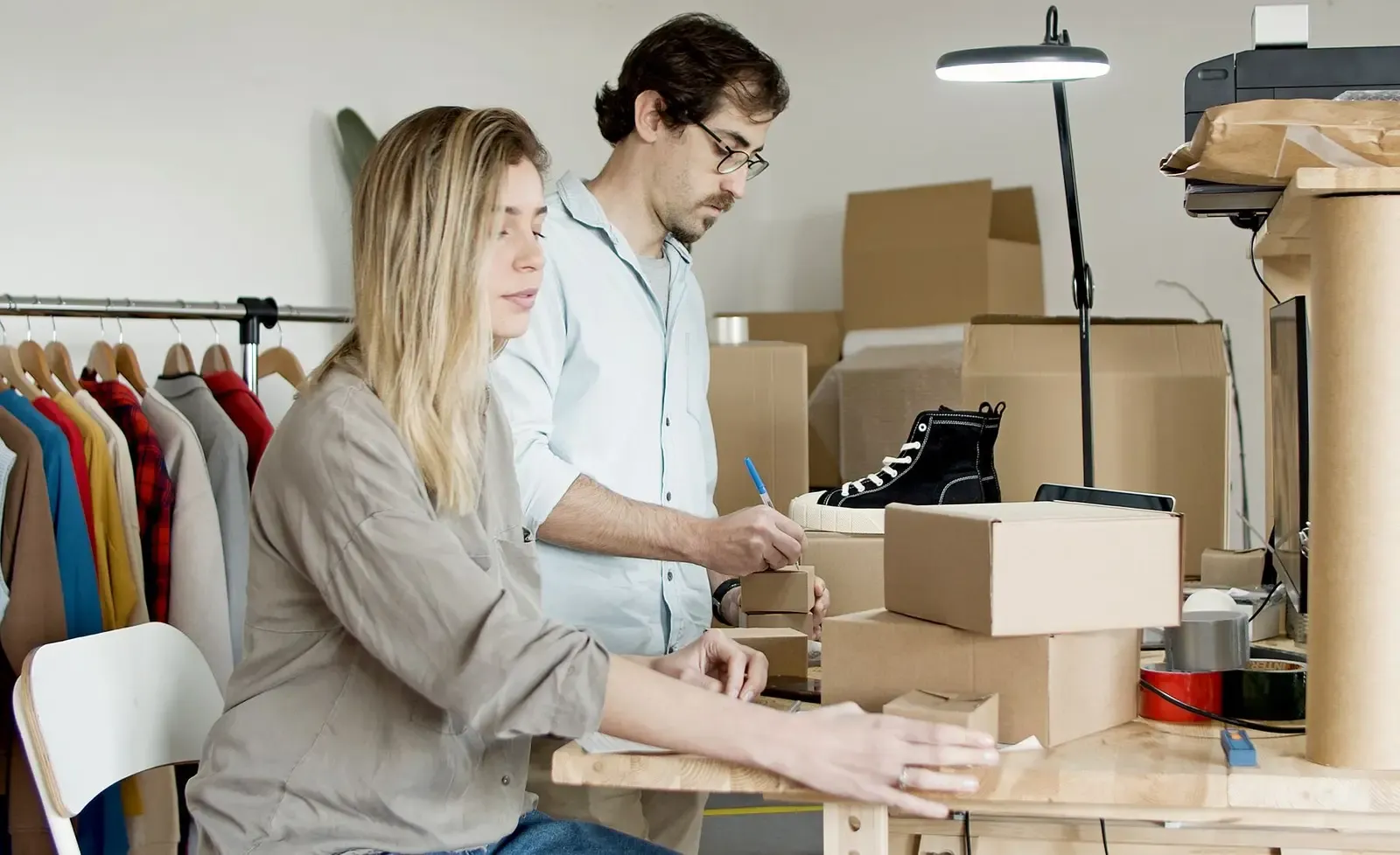 Two small-business owners packing products and managing inventory