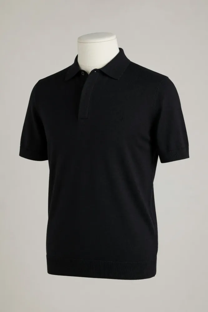 Black hidden-placket short-sleeve knit polo with collar and ribbed hem shown on a mannequin for private-label development