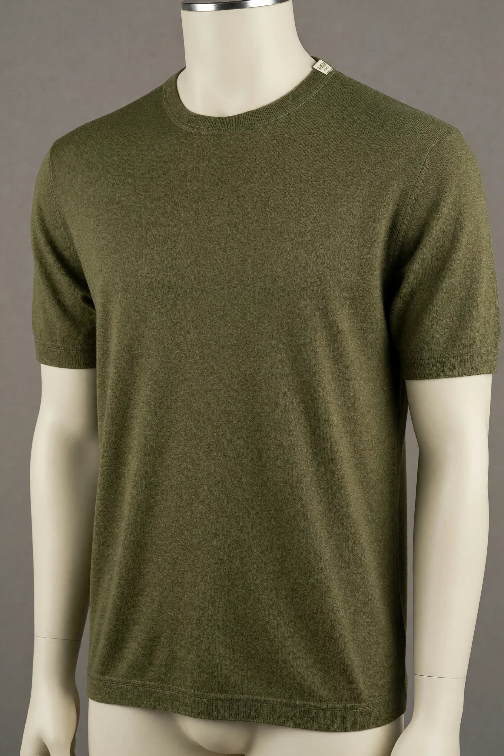 Olive fine-surface crew-neck knit tee with short sleeves, narrow collar and flat cuffs photographed on a faceless mannequin for private-label apparel development